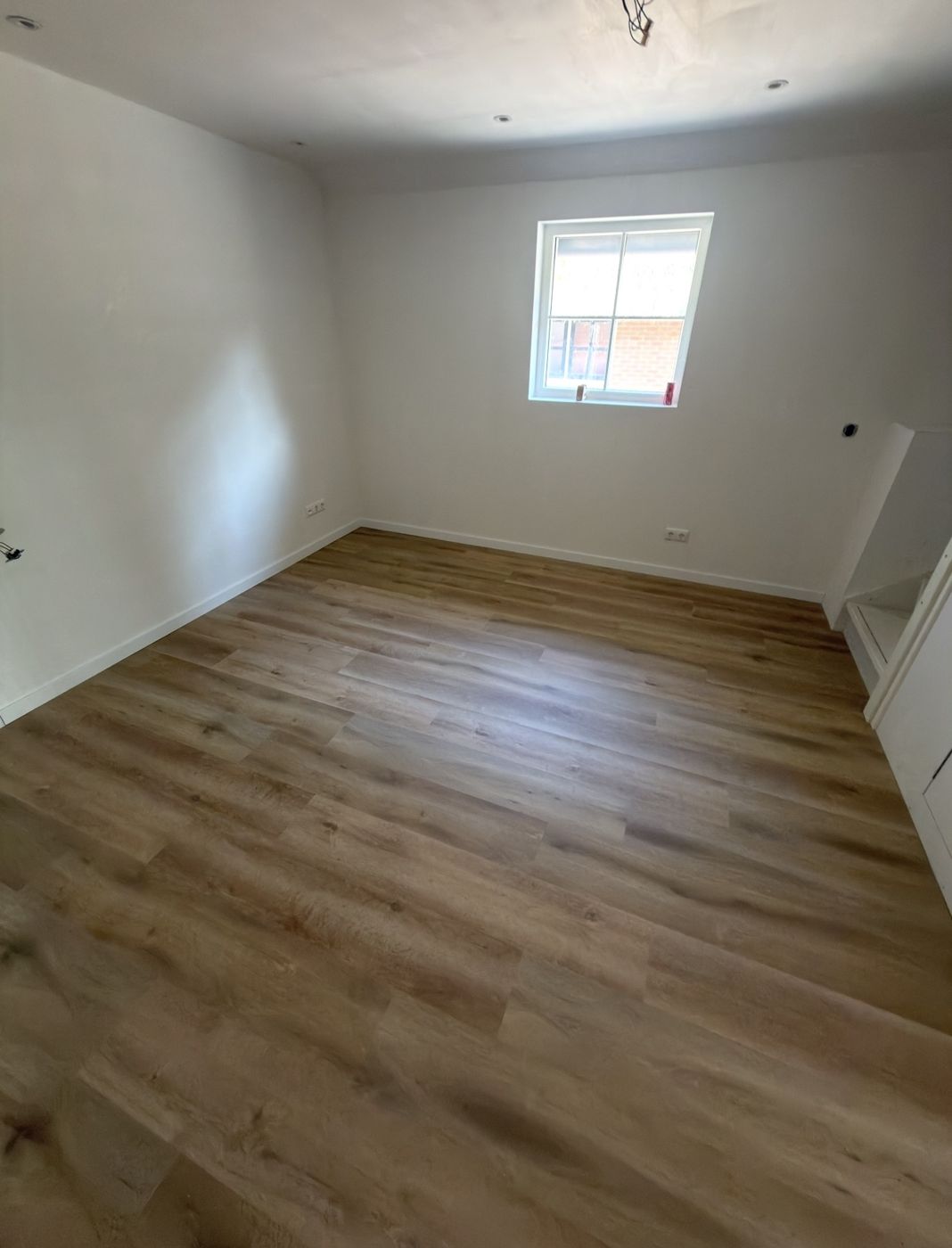 Kamer met nieuwe PVC-vloer en witte plinten